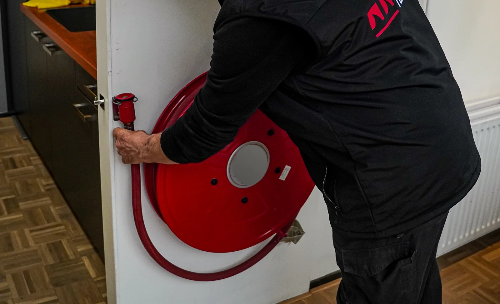 Monteur van Brandpreventie Techniek keurt een brandslanghaspel